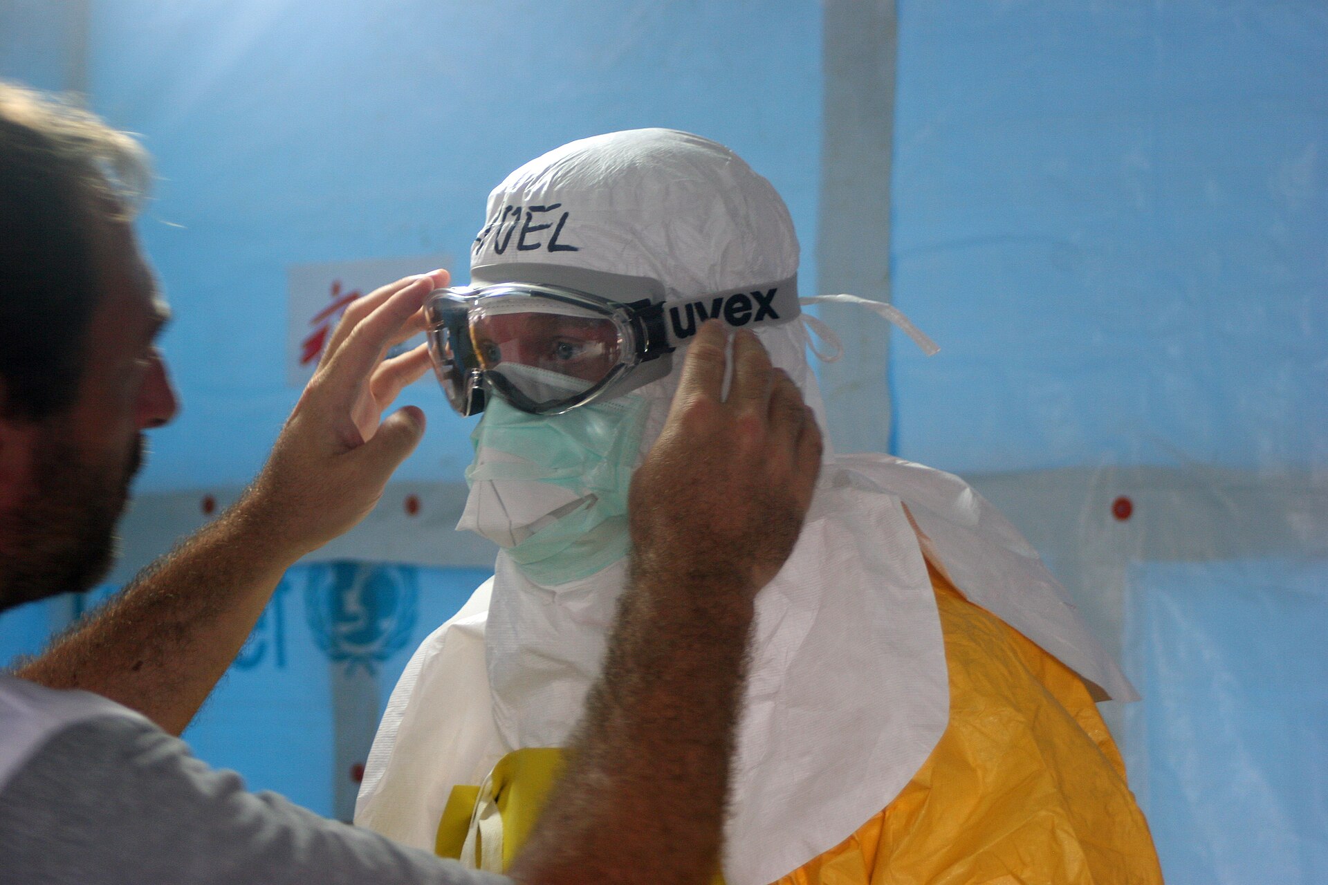 Health workers in protective suits preparing to enter an Ebola treatment unit